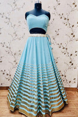 AFL1054-Chiffon Lehenga in Blue comes with vertical stripes gold Zari work on the border and  with Net Dupatta. Also Comes with a matching stitched corset blouse and jacket.