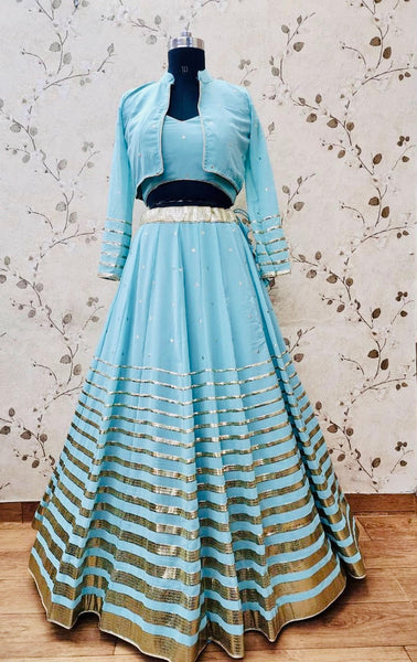 AFL1054-Chiffon Lehenga in Blue comes with vertical stripes gold Zari work on the border and  with Net Dupatta. Also Comes with a matching stitched corset blouse and jacket.